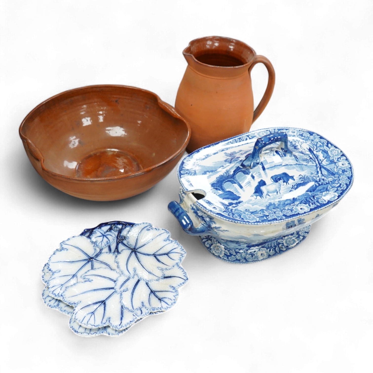 An early 19th century pearlware tureen, a pair of pearlware leaf dishes, a glazed earthenware jug and basin